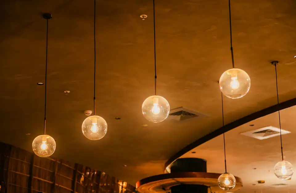 Glass globe pendant lights glowing under a curved ceiling