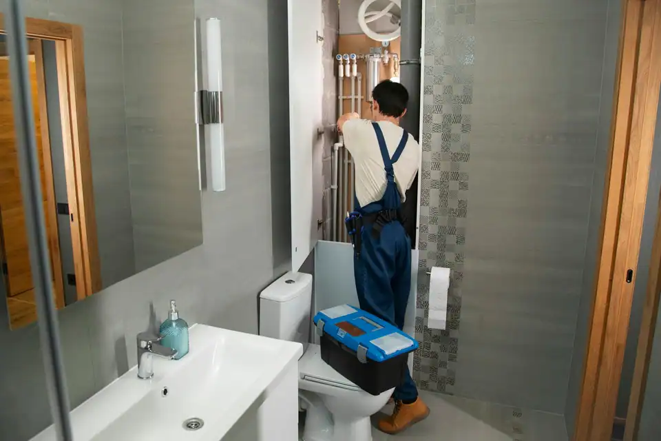 A Hartley plumber arriving at a bathroom job with his toolbox