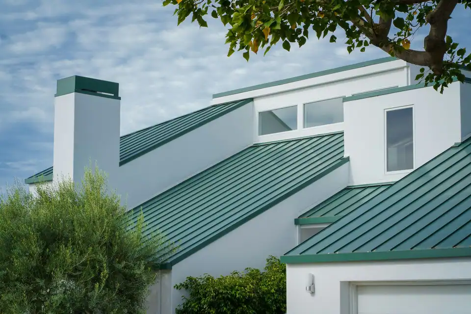 White house with green metal roof panels